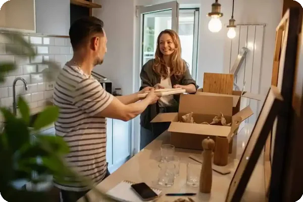 Couple unpacking dishes and kitchen items from moving boxes