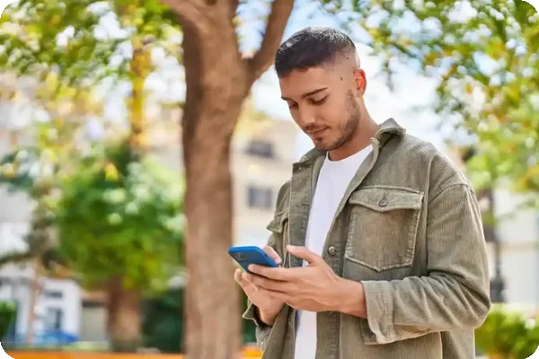 Man checking phone while walking in his neighborhood