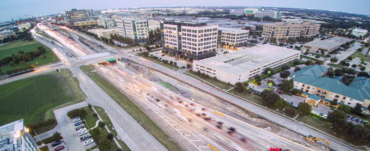 Traffic along a major highway beside multistory buildings in Plano, TX