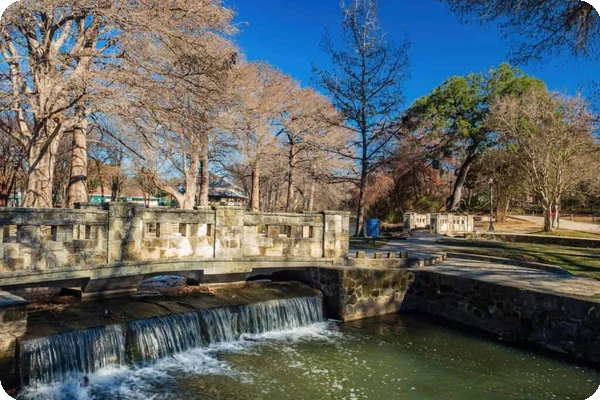 A view of a bridge and stream in Brackenridge Park, located in the Monte Vista neighborhood of San Antonio