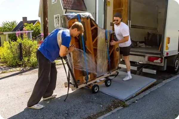 Two men loading a piano onto a moving truck