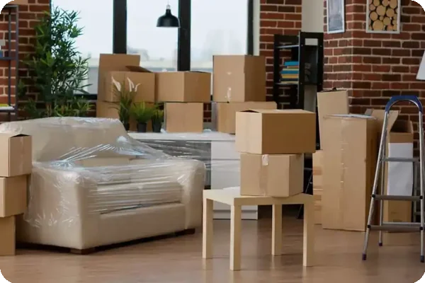 Living room filled with packed moving boxes and wrapped furniture