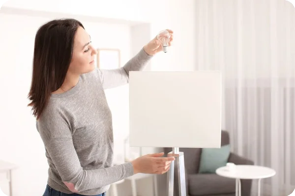 A woman removes a lightbulb from a white floor lamp