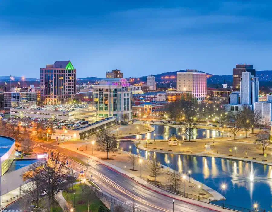 Cityscape with lit streets and a water feature at dusk near Madison, AL.