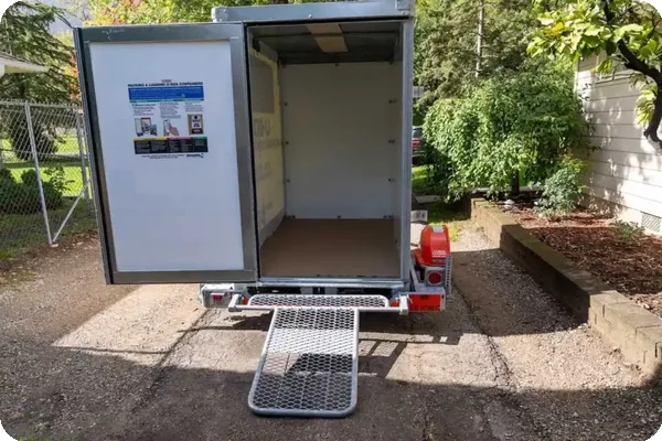 Open moving container with loading ramp, ready for packing household items