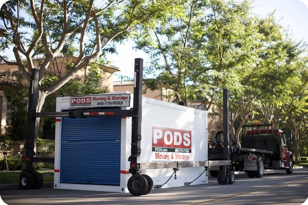 A PODS moving container delivered by a specialized lift truck and lowered into a driveway