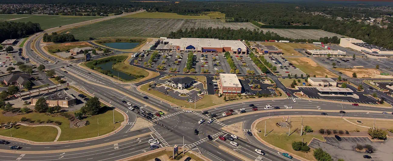 Am aerial view of a busy intersection, buildings, and the distant treeline in Warner Robins, GA