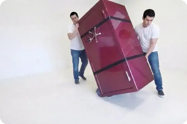 two men start moving a safe using a dolly and moving straps