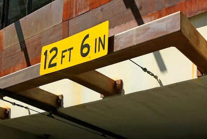 A yellow clearance height sign that indicates the clearance for vehicles is 12 feet 6 inches 