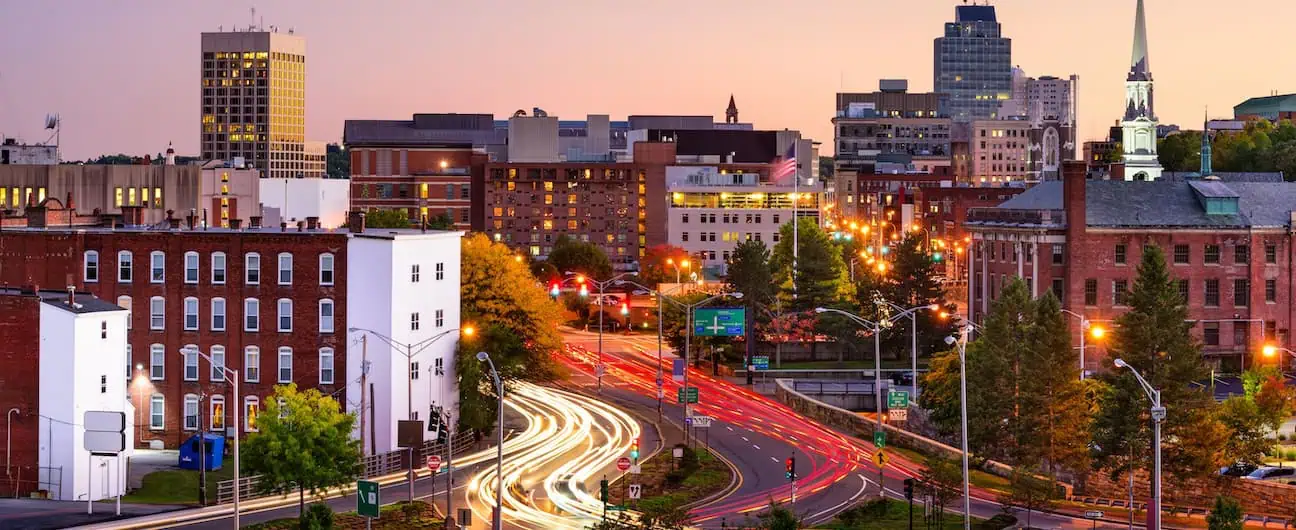 The skyline and busy streets of Worcester, MA at sunset