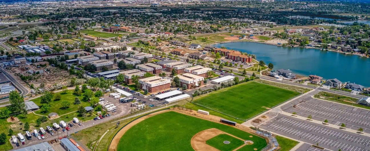 A view of homes, businesses, and a baseball field in Westminster, CO