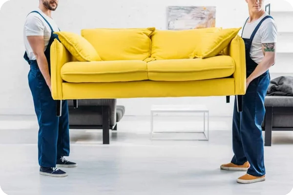 Two movers lift a bright yellow couch