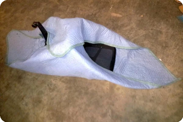 an image of an office chair being wrapped, as instructed, with a moving blanket