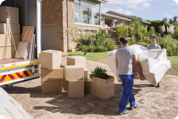 Movers carrying sofa from house to moving truck
