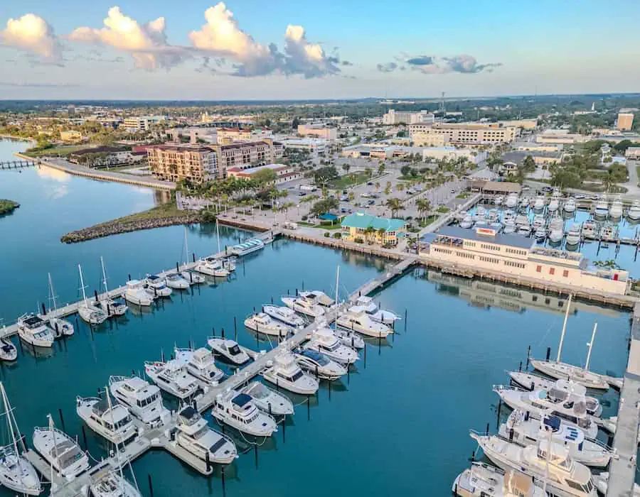 Marina view in Port Saint Lucie, FL with boats docked and buildings in the background.