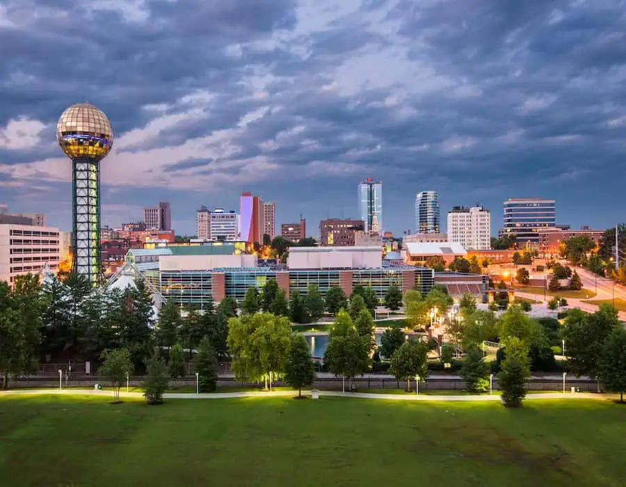 Downtown Knoxville skyline at dusk with the Sunsphere and clouds overhead. 