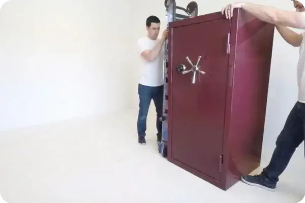 two men load a safe onto a dolly