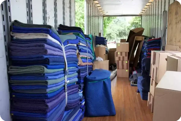 Stack of moving blankets and cardboard boxes inside a moving truck