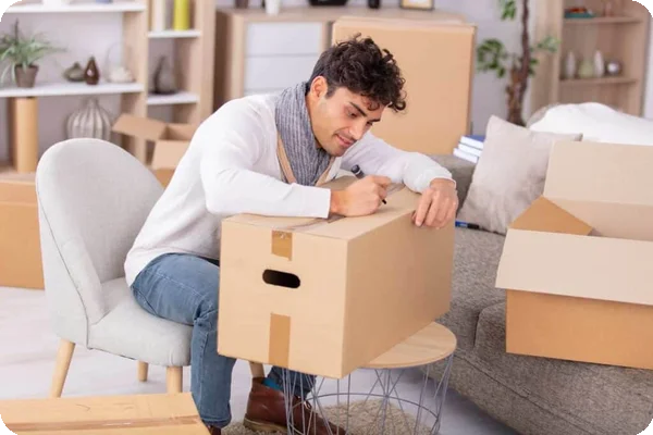 a man uses a marker to label a moving box