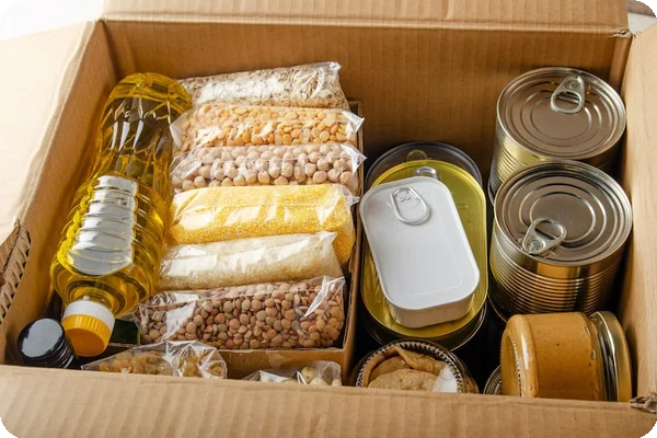 Pantry shelves with canned goods, dry foods, and spices being sorted into moving boxes