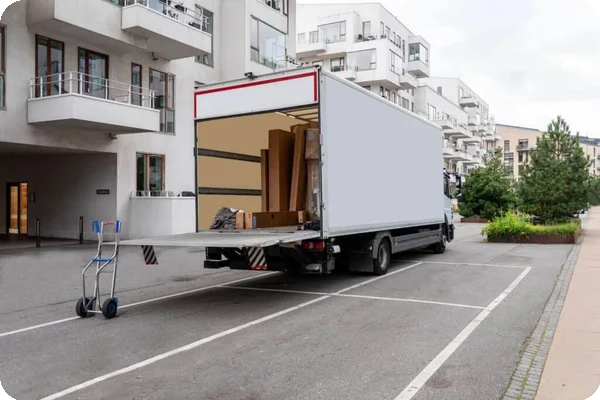 A moving truck parked in front of an apartment building