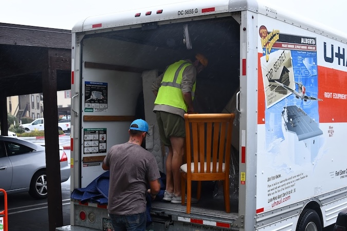 Some movers unloading a H-Haul Rental Truck