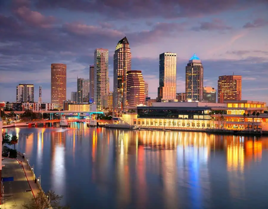 Aerial cityscape image of Tampa, Florida, with reflection of the city skyline in the water at beautiful sunrise.