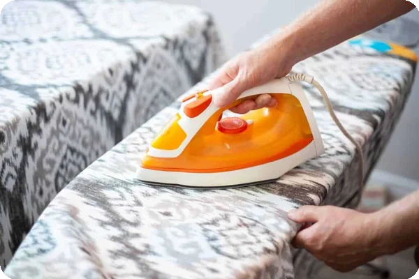 a person irons curtains with a geometric pattern
