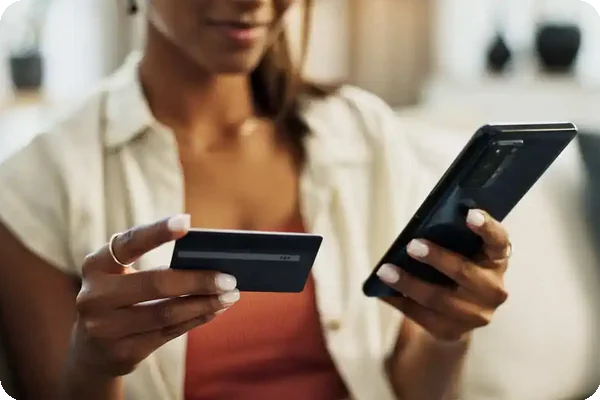 Person holding a credit card and phone, paying movers for relocation services