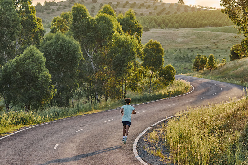 ASICS Athlete running on a road.