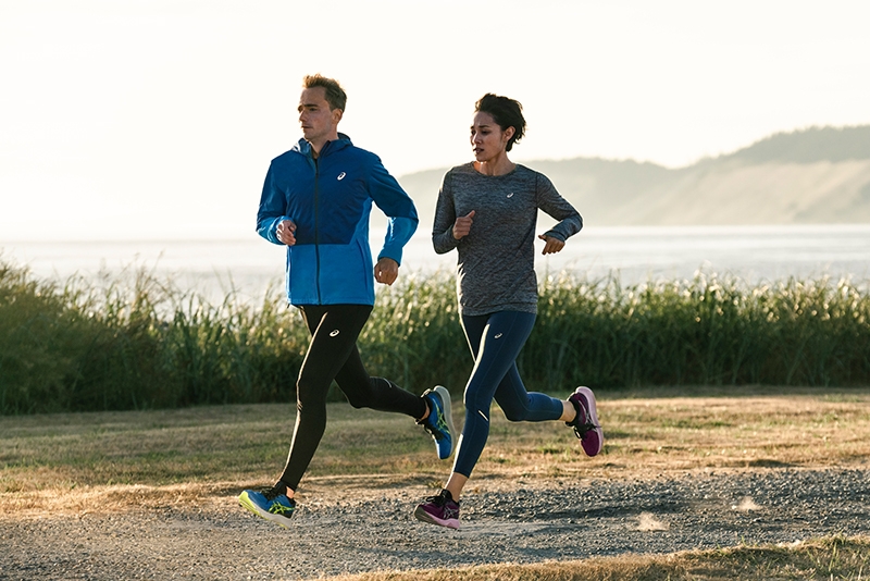 Two People running outside in ASICS shoes and gear