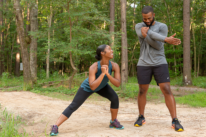 2 runners stretching on a trail