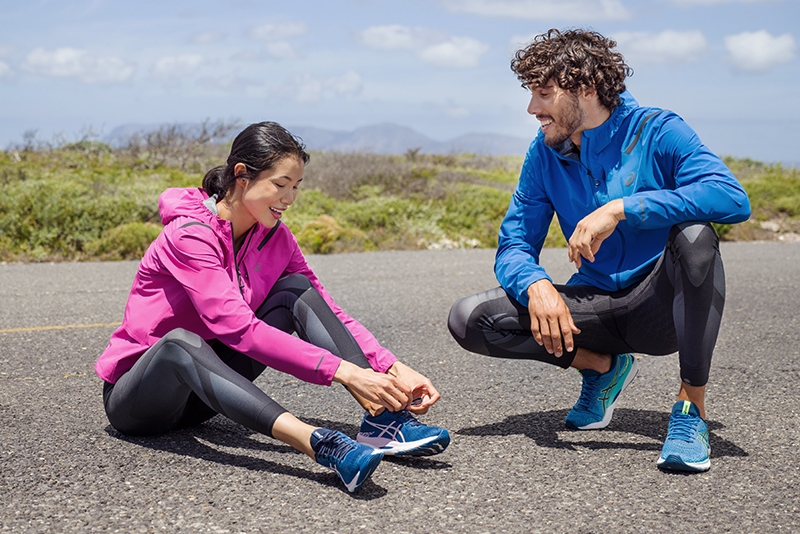 Two people tying there running shoes
