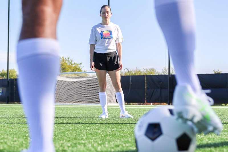 ASICS Athletes playing soccer on a soccer field.