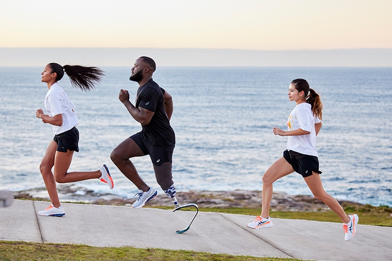 Three people running the beach