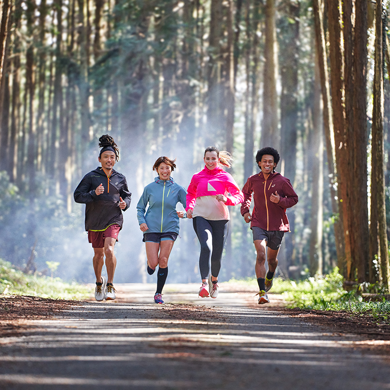Four runners running on a trail