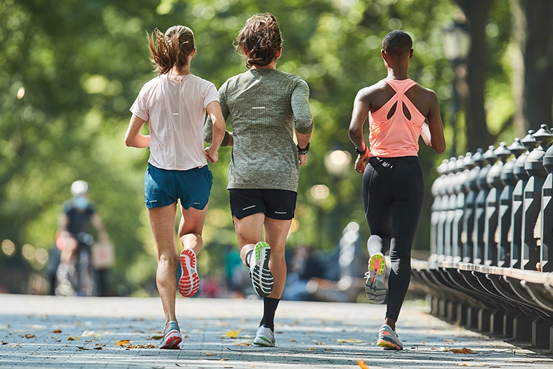 Three people running in ASICS running shoes