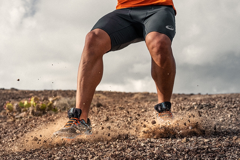 Runner jumping in dirt and rocks