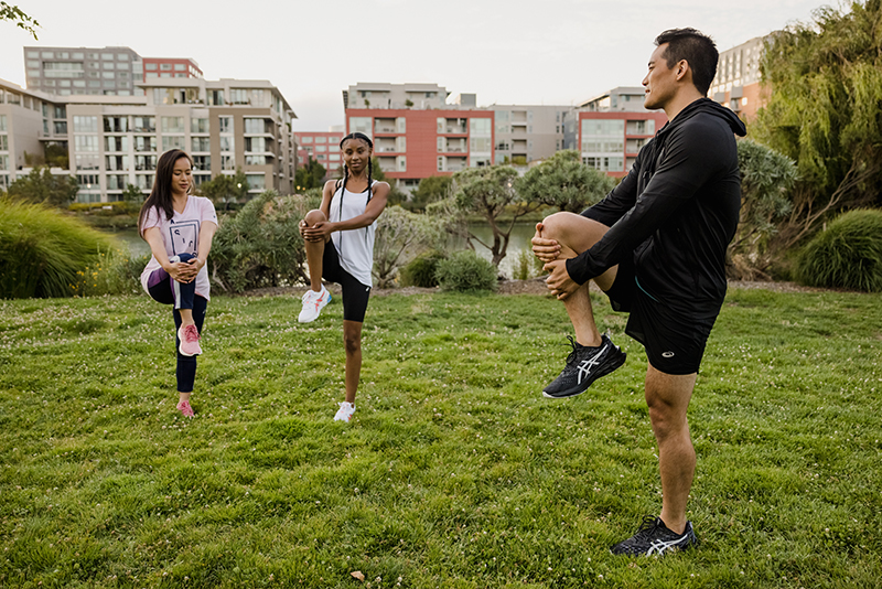 Man and two women stretching there legs in a field