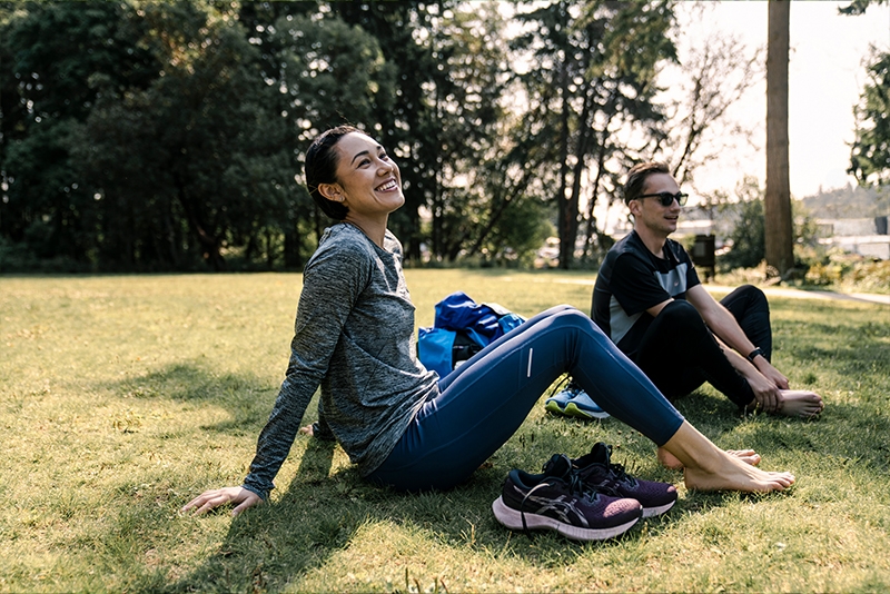 Women and man sitting outside on the grass