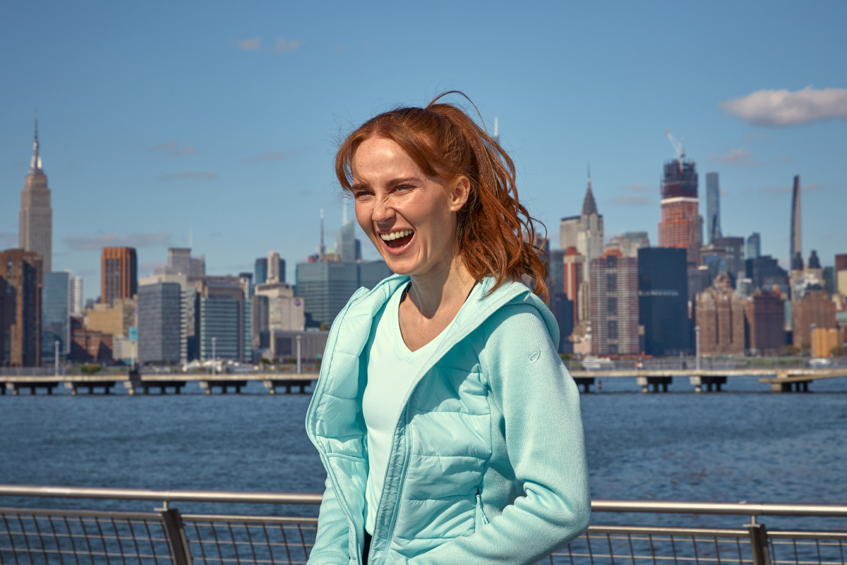 ASICS Athlete laughing in front of a city skyline