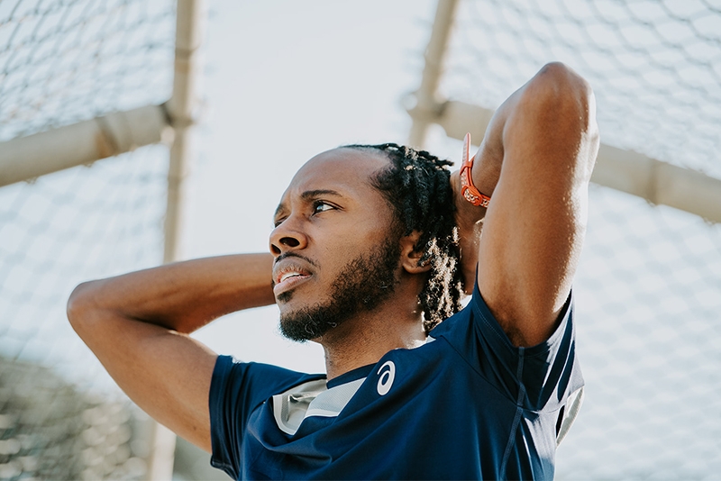 Man outside with his hands on his head thinking