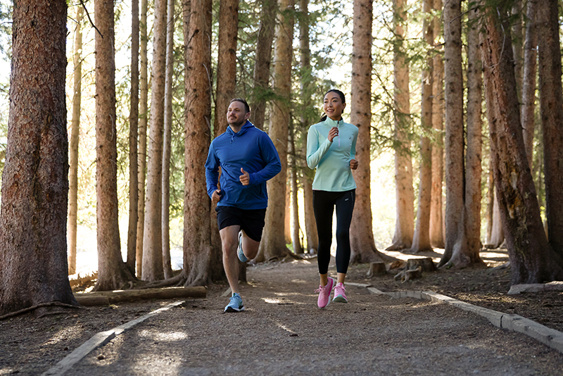 Two people running in woods