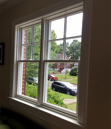 the interior view of a home with two white double-hung windows