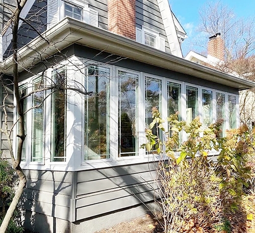 Exterior closeup view of a Haddonfield home's sunroom with newly installed Pella casement windows.