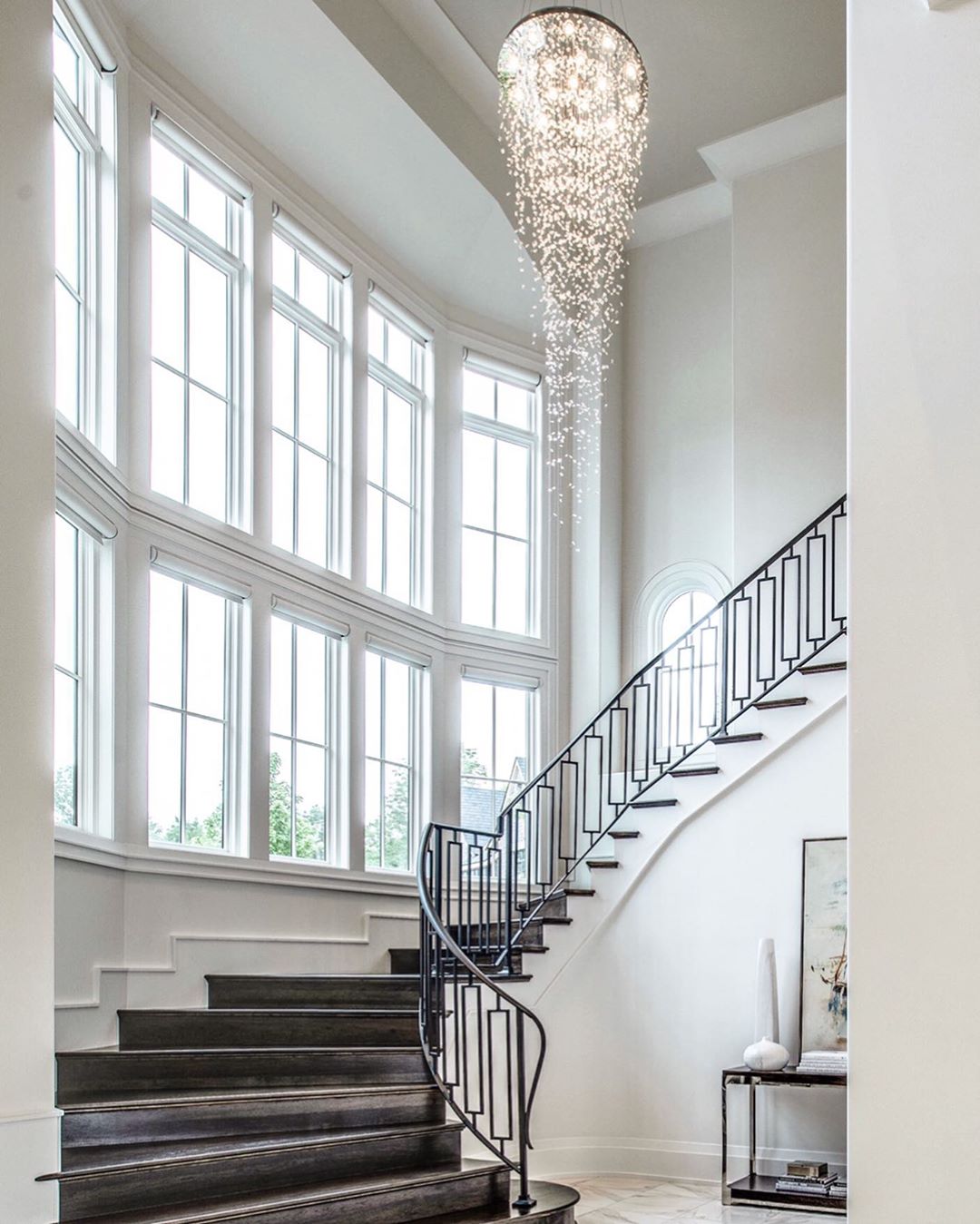 grand staircase overlooking two rows of white fixed windows bringing in natural light