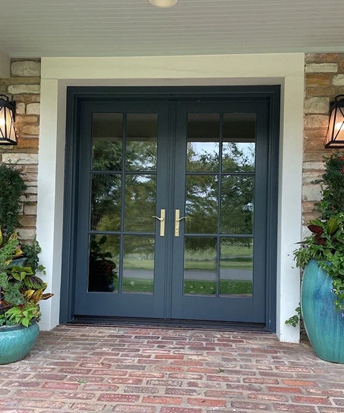 new black front door on brick patio looks sharp