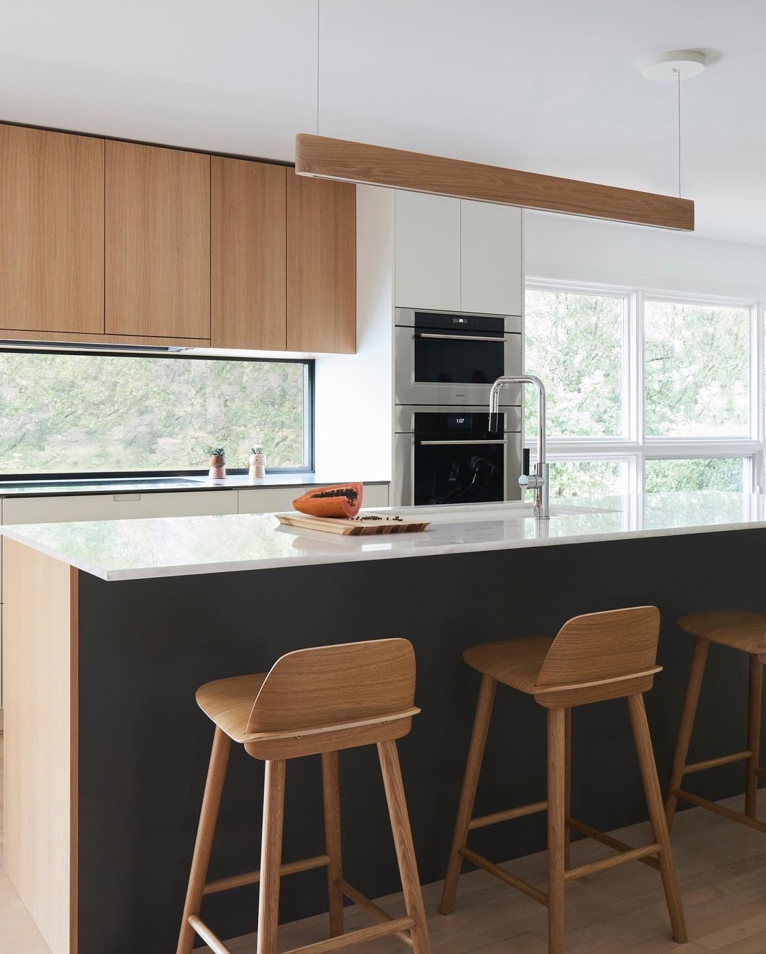 Kitchen window backsplash sits above white countertops and below modern wood cabinets.