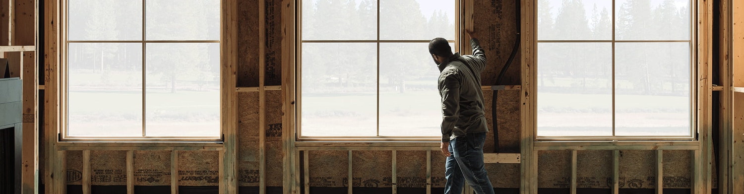 contractor standing near the windows of a new home under construction