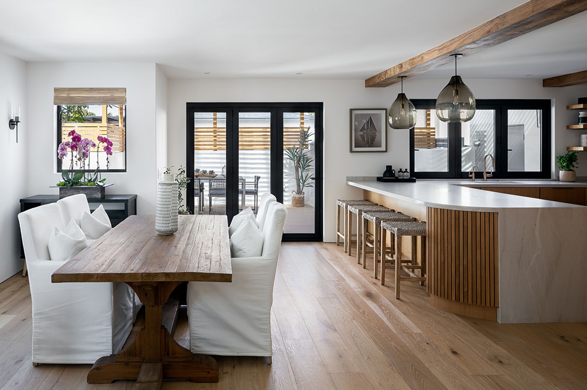 Black sliding patio doors in an outdoor entertaining space with a fireplace and furniture on the deck